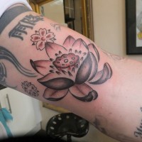 Detailed lotus with buddhist symbol tattoo on arm