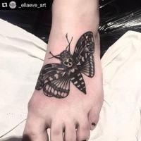 Detailed moth  decorated with skull dark tattoo on foot