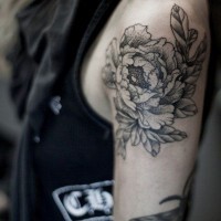 Detailed peony flower black and white tattoo on upper arm