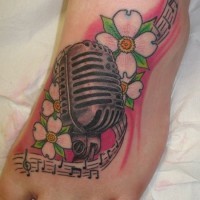 Tatuaje en el pie, micrófono entre flores y melodía