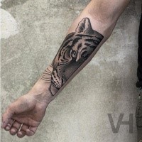 Dot style black ink forearm tattoo of split tiger head by Valentin Hirsch