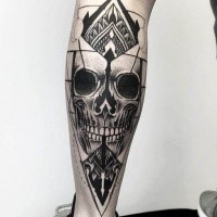 Dot style black ink leg tattoo of human skull with ornaments