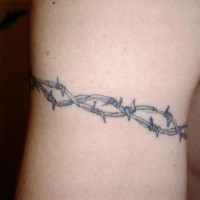 Tatuaje en el brazo,
 alambre de espina gris
