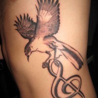 Tatuaje en el costado, ave que lleva un clave de sol