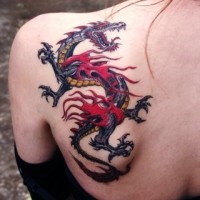 Tatuaggio colorato sulla spalla il dragone con la bocca spalancata