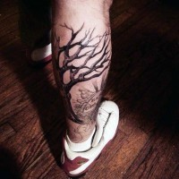 Dramatic black ink lonely tree on cemetery tattoo on leg