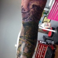 Dramatic colored sleeve tattoo of cemetery with dark sky and lightning
