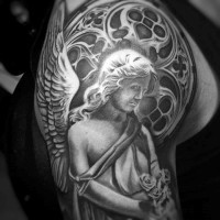Dramatic looking black ink angel statue with flowers tattoo on shoulder