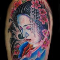 Dramatic natural colored shoulder tattoo of sad geisha portrait