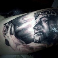 Dramatic style black ink biceps tattoo of Jesus portrait