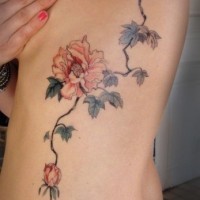 Tatuaje en las costillas, ramita con tres flores