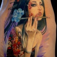 Tatuaje en las costillas, geisha suave con un flor azul