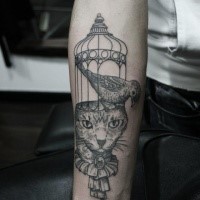 Engraving style black ink arm tattoo of cat head with bird and cage