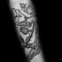 Engraving style black ink arm tattoo of rose with bone hand