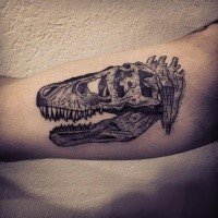 Engraving style black ink biceps tattoo of dinosaur skeleton