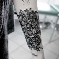 Engraving style black ink flower tattoo on forearm combined with lettering