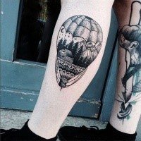 Engraving style black ink leg tattoo of large balloon stylized with forest house and mountains