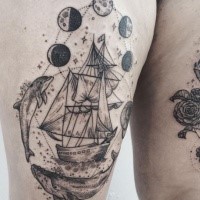 Engraving style black ink sailing ship tattoo on thigh with moon cycle and whales
