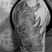 Engraving style black ink shoulder tattoo on rhino head