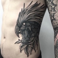 Engraving style black ink side tattoo of parrot with leaves