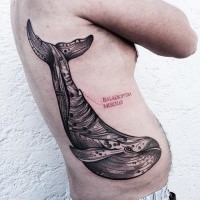 Engraving style black ink side tattoo of big whale with lettering