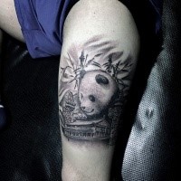 Engraving style black ink tattoo of big panda with house