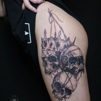Engraving style black ink thigh tattoo of human skulls with crown
