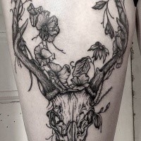 Engraving style black ink thigh tattoo of deers skull with flowers