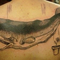 Engraving style black ink upper back tattoo of large whale with small flower in pot