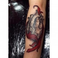 Engraving style colored arm tattoo of human heart with flames