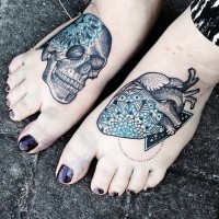 Engraving style colored human heart and skull tattoo on feet stylized with blue ornamental flowers