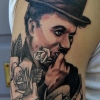 Engraving style half colored shoulder tattoo of Charlie Chaplin with roses