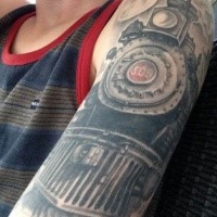 Enormous colored upper arm tattoo of old iron steam train