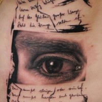 Auge und Text Tattoo an Rippen