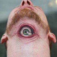 Tatuaggio colorato sulla gola l'occhio grande