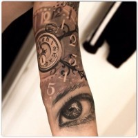 Tatuaje en el brazo de ojos y un reloj por Jak Connolly.