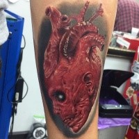 Fantastic designed and colored heart shaped tattoo of evil alien head