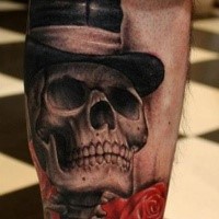 Fantastic looking black and gray style forearm tattoo of gentleman skull and red rose