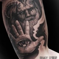 Fantasy style colored biceps tattoo of devil with human eye on hand