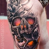 Fantasy style colored thigh tattoo of big human skull with roses