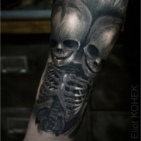 Stile fantasy dettagliato raccapricciante dipinto da Eliot Kohek tatuaggio dello scheletro con due teschi