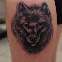 Feminine wolf face tattoo on leg