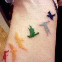 Flock of colored birds tattoo