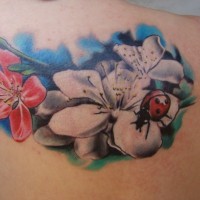 Tatuaje en el hombro, flores y mariquita pequeña
