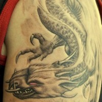 Tatuaggio grande sul deltoide il dragone che vola