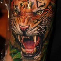 Tattoo von Tigerkopf im Wald auf der Arm