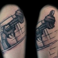 Funny black and gray style shoulder tattoo of pistol with barrel tied in knot