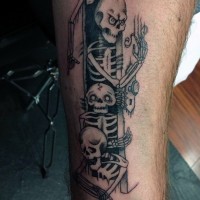Tatuaje en la pierna, cuatro esqueletos divertidos en la puerta