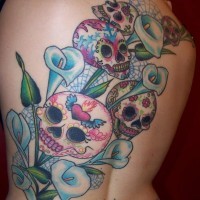 Lustiger cartoonischer traditioneller mexikanischer Schädel Tattoo am Rücken mit blauen Blüten