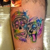 Funny cartoon style colored smiling skull with dog tattoo on leg